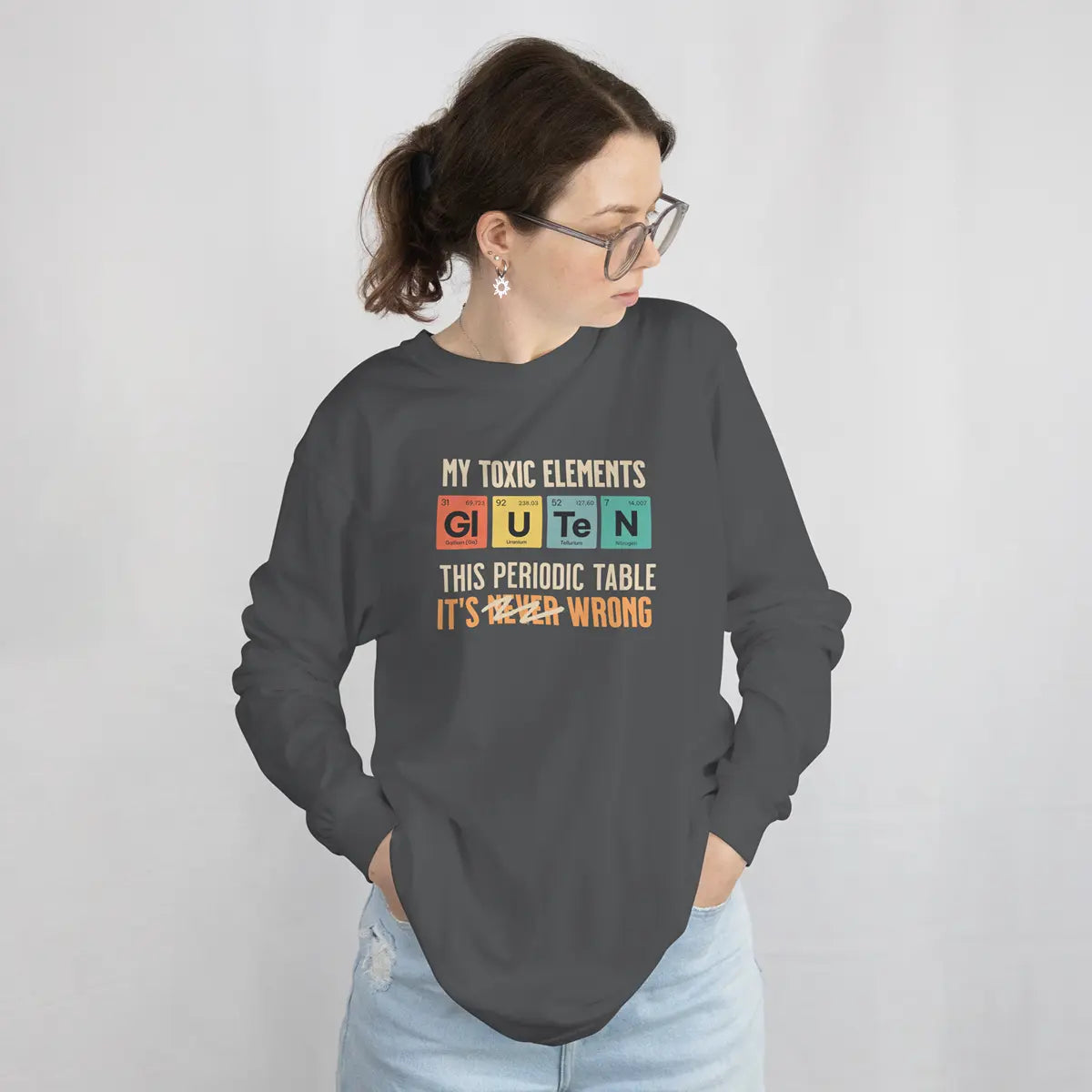 Mujer con una sudadera gris carbón con el diseño de la tabla periódica Mis elementos tóxicos, para celiacos